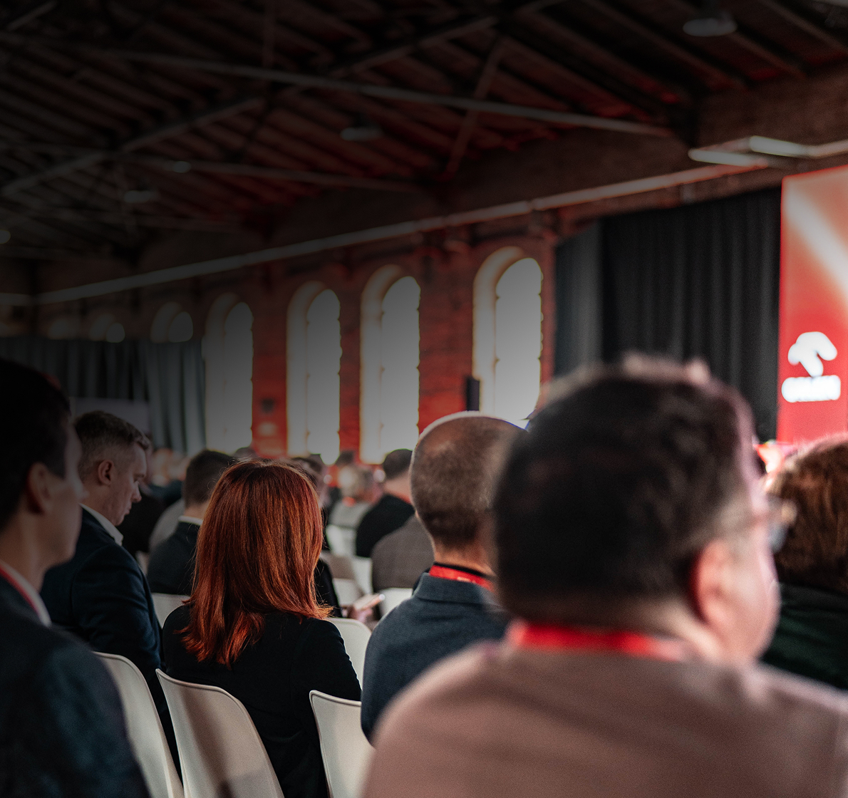 Publiczność na sali konferencyjnej, widok z tylnych rzędów.
